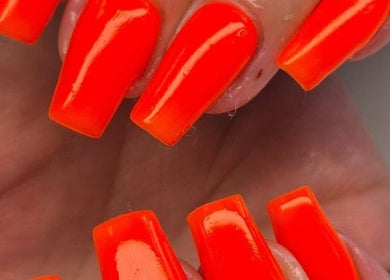 Bright orange nails at The Beauty Basement in Pudsey, England, GB showcasing vibrant manicure style.