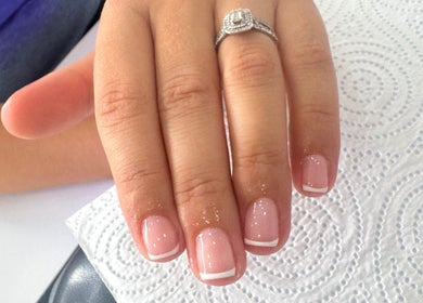 French manicure at The Beauty Basement, Pudsey, England, GB. Hand with elegant nails and ring.