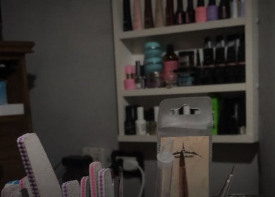 Herramientas de manicura en Nails By Bianca, Piñeyro, Provincia De Buenos Aires, AR, con estantes llenos de esmaltes.