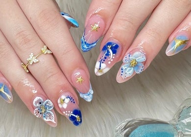 Elegant blue and gold nail art at Nailvana, Cincinnati, Ohio, US showcasing intricate design details.