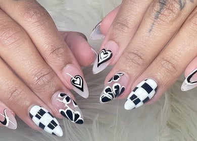 Stylish black and white nail art by Nailvana located in Cincinnati, Ohio, US. Intricate patterns displayed.