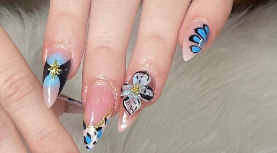 Intricate blue and floral nail art at Nailvana, Cincinnati, Ohio, US, showcasing creative manicure designs.