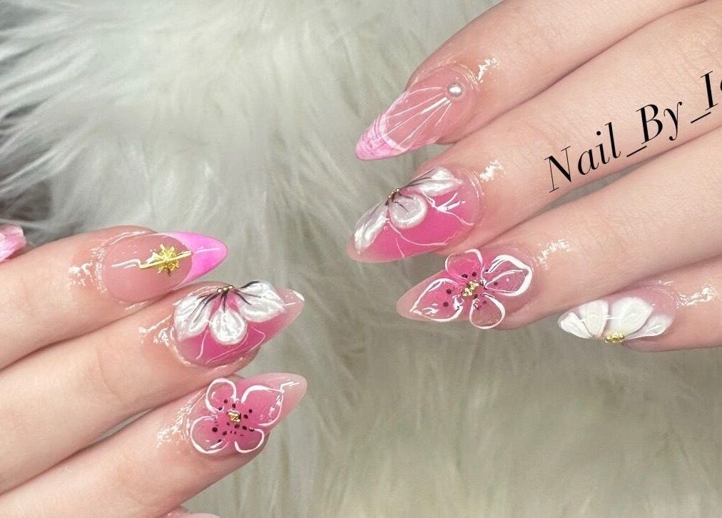 Elegant floral nail art at Nailvana, Cincinnati, Ohio, US. Pink and white petals adorn manicured hands.
