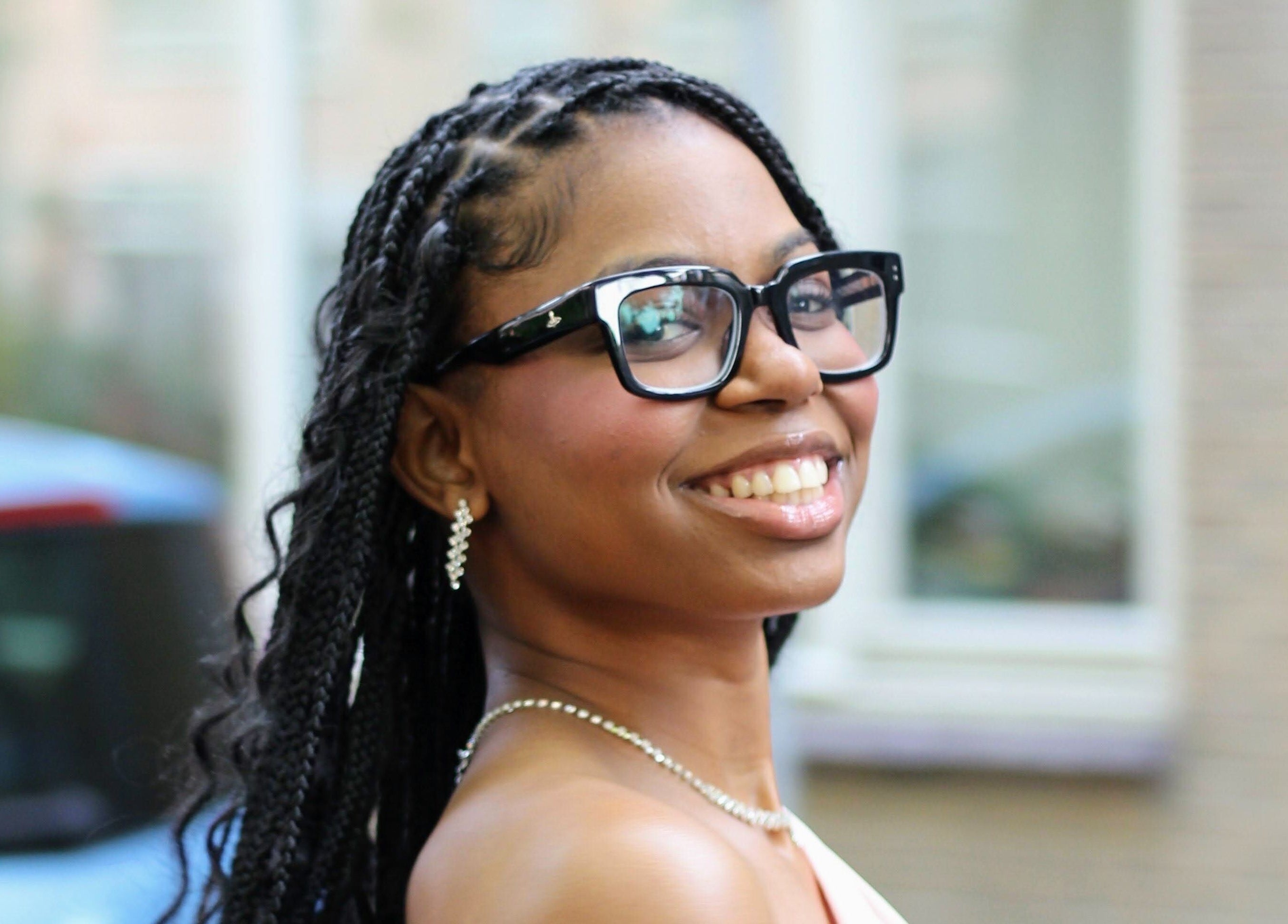 Woman smiling gracefully near Nevia Glam, NL, showcasing elegance and style.