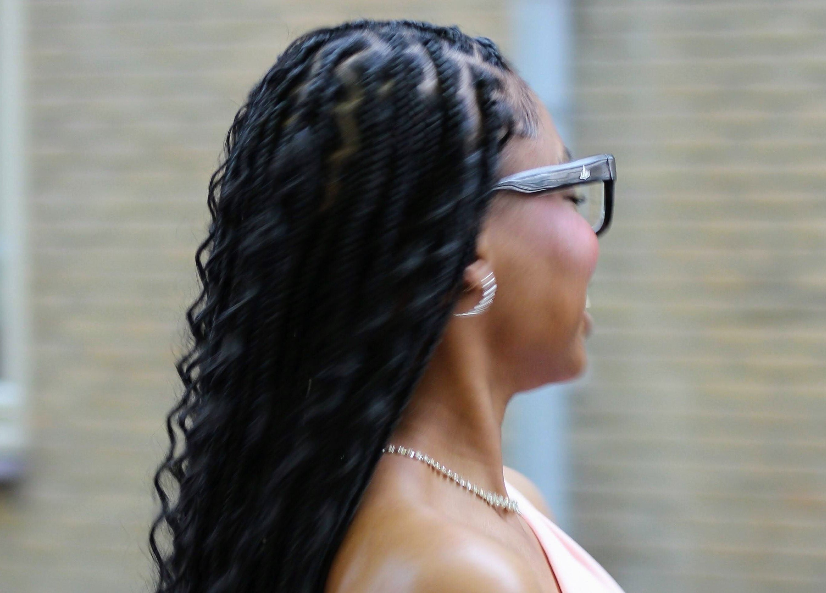 Woman with elegant braids at Nevia Glam salon NL, showcasing stylish hair design.