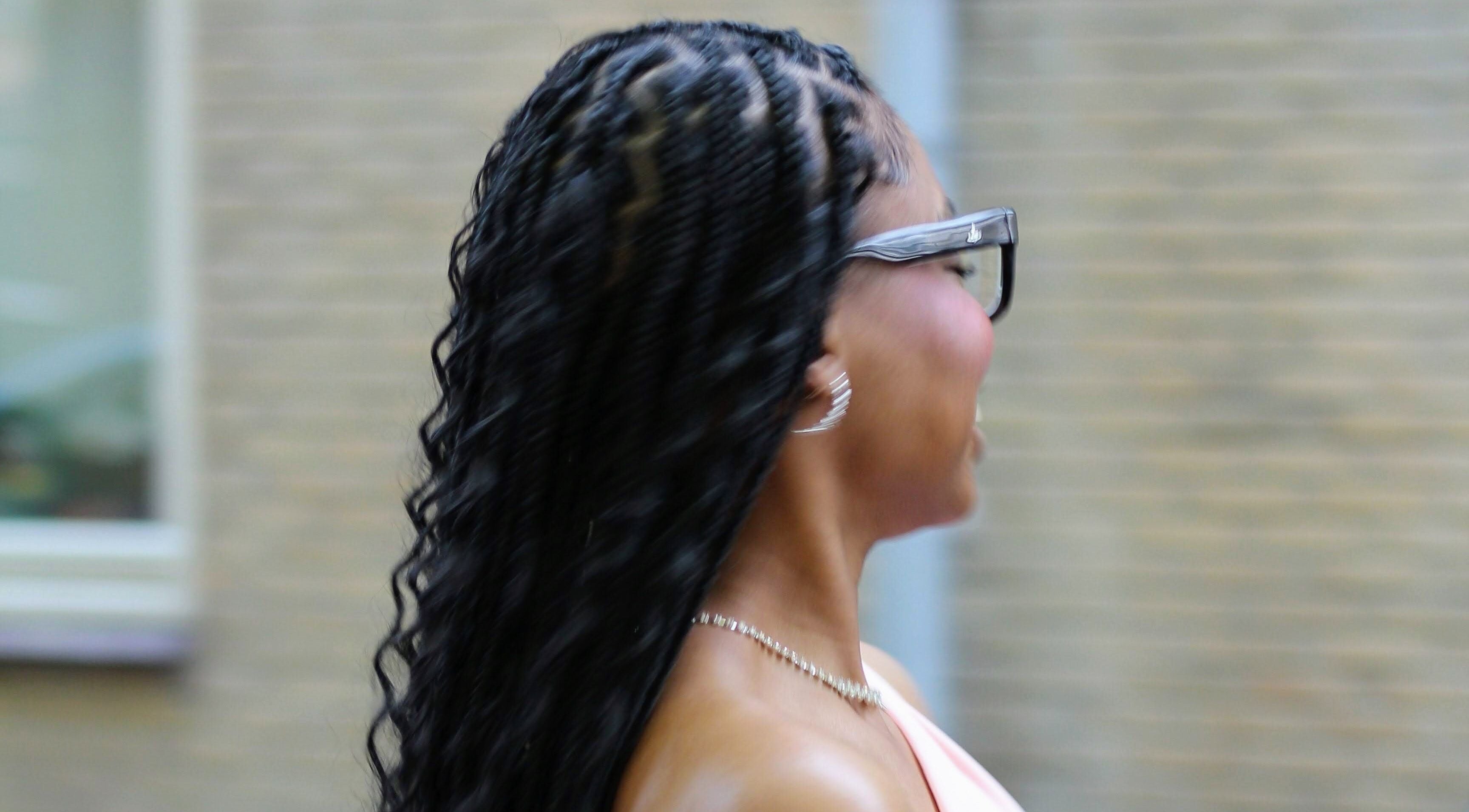 Woman with elegant braids at Nevia Glam salon NL, showcasing stylish hair design.