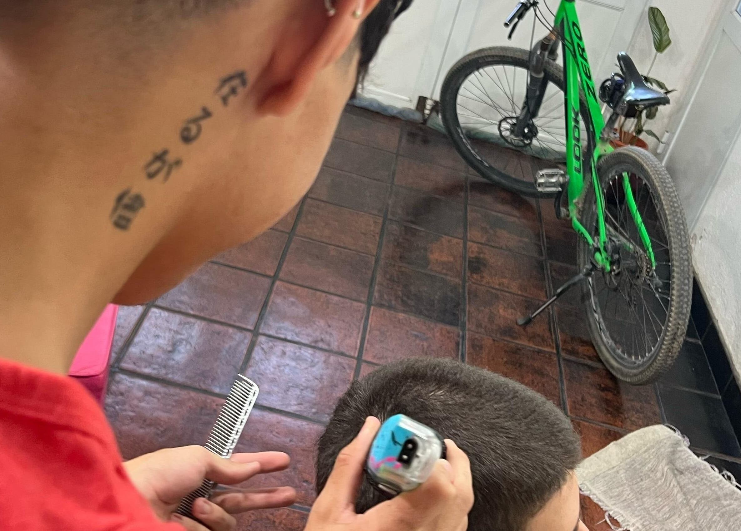 Estilista de Suru Barber en Carcaraña, Santa Fe, AR realizando un corte moderno.