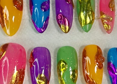 Palette vibrante de faux ongles chez Nazca Beauty à Montréal, Québec, CA, offrant des designs multicolores uniques.