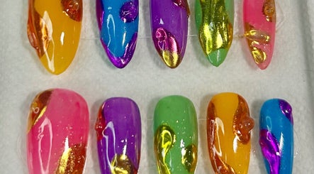 Palette vibrante de faux ongles chez Nazca Beauty à Montréal, Québec, CA, offrant des designs multicolores uniques.