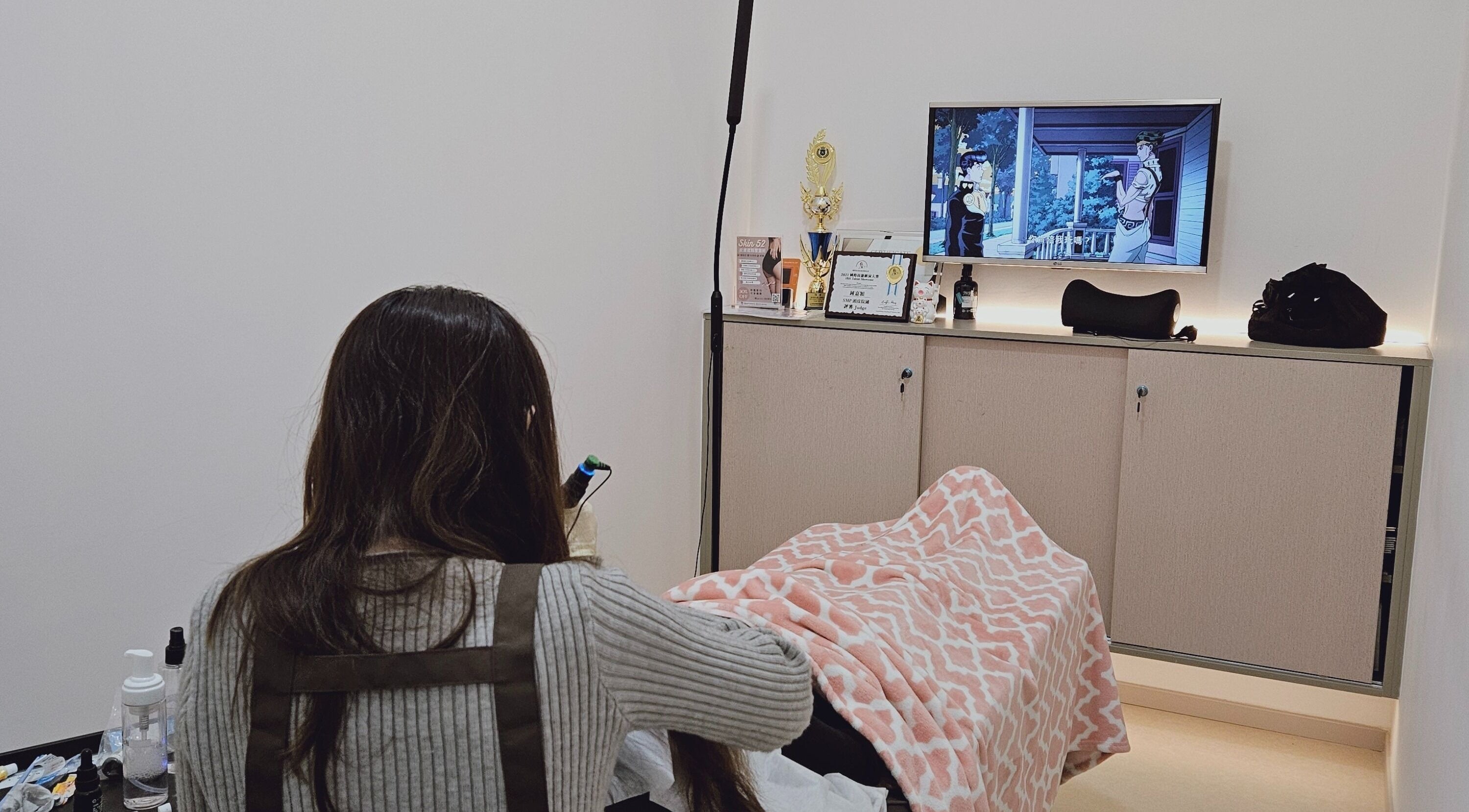 A serene treatment room at AOh Beauty, Kowloon, Kowloon, HK, featuring a cozy blanket and elegant decor.