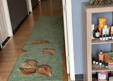 Lido Massage hallway in Gainesville, Georgia, US featuring a serene rug and wellness products displayed on a shelf.