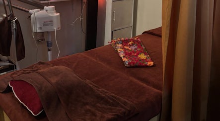Massage bed setup at The Beauty Room, Singapore, Singapore, SG with warm lighting and a floral towel.