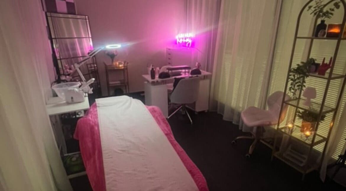 Beauty By RJ salon in Blantyre, Scotland. Cozy treatment room with a pink-lit ambiance for a relaxing experience.