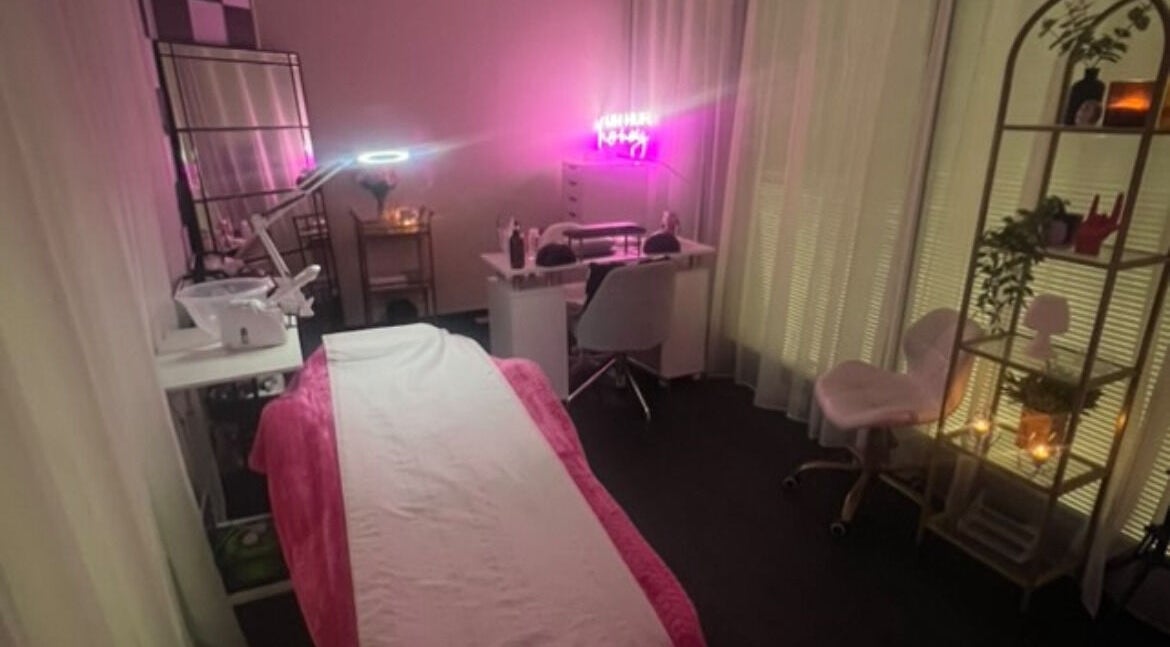 Beauty By RJ salon in Blantyre, Scotland. Cozy treatment room with a pink-lit ambiance for a relaxing experience.