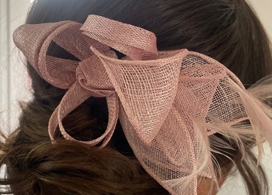 Elegant pink fascinator hairstyle, Styled by Jenna in Blantyre, Scotland, GB, showcases delicate textured bow.