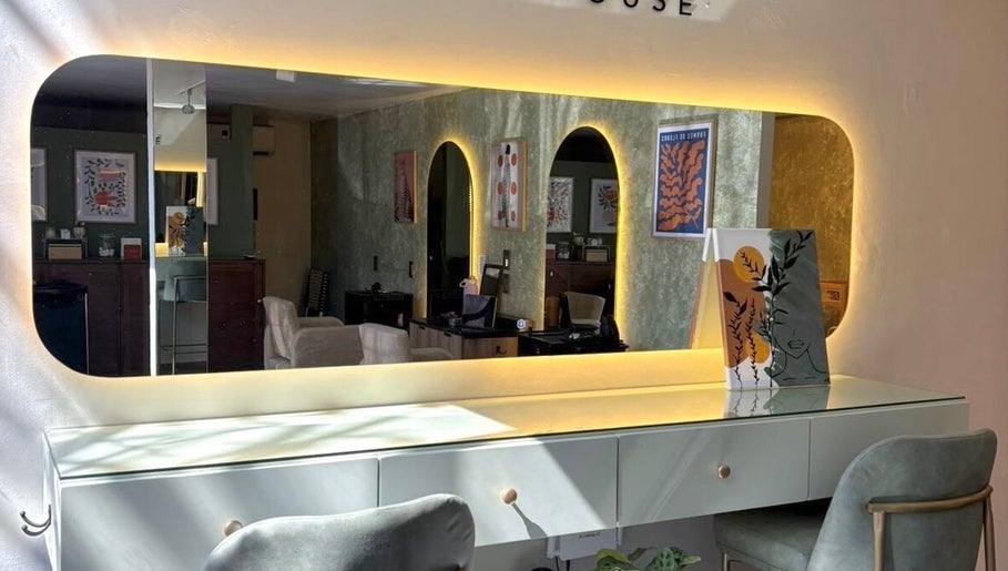 Interior de ESMARA NAIL SPA en Guadalajara, Jalisco, MX, con elegante espejo iluminado y decoración moderna.