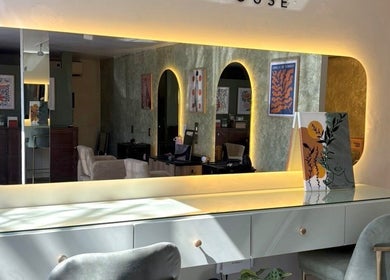 Interior de ESMARA NAIL SPA en Guadalajara, Jalisco, MX, con elegante espejo iluminado y decoración moderna.