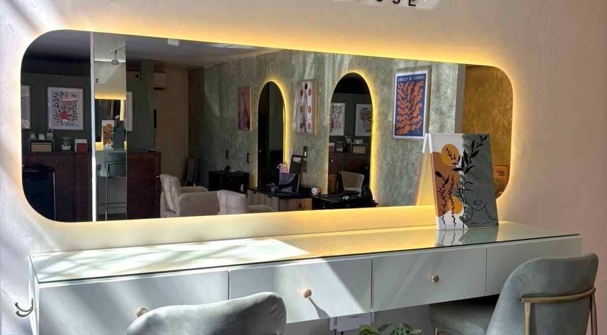 Interior de ESMARA NAIL SPA en Guadalajara, Jalisco, MX, con elegante espejo iluminado y decoración moderna.