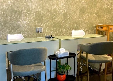 Elegante área de manicura en ESMARA NAIL SPA, Guadalajara, Jalisco, MX, con sillas modernas y decoración sofisticada.