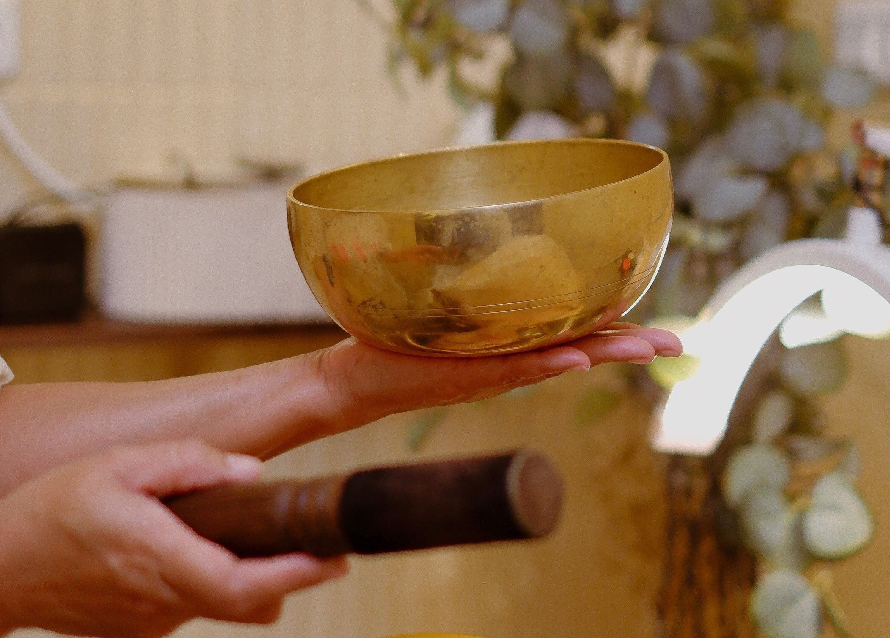 Therapist uses sound bowl therapy at BYLU Scalp & Body Spa, Daerah Istimewa Yogyakarta, ID.
