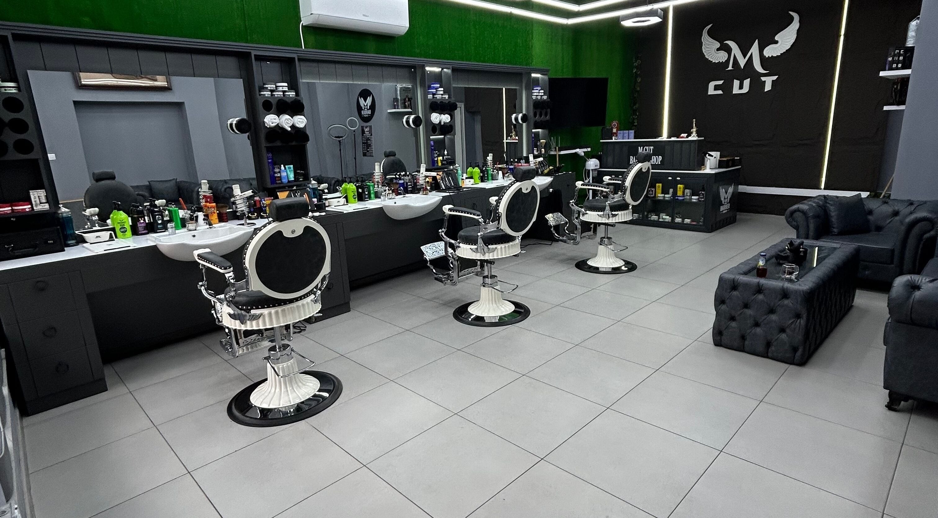 Интериор на салона M.cut в Ямбол, Ямбол, BG, с модерни бели бръснарски столове и елегантен декор.