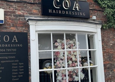 Elegant facade of Coa Hair in York, England with floral display window.
