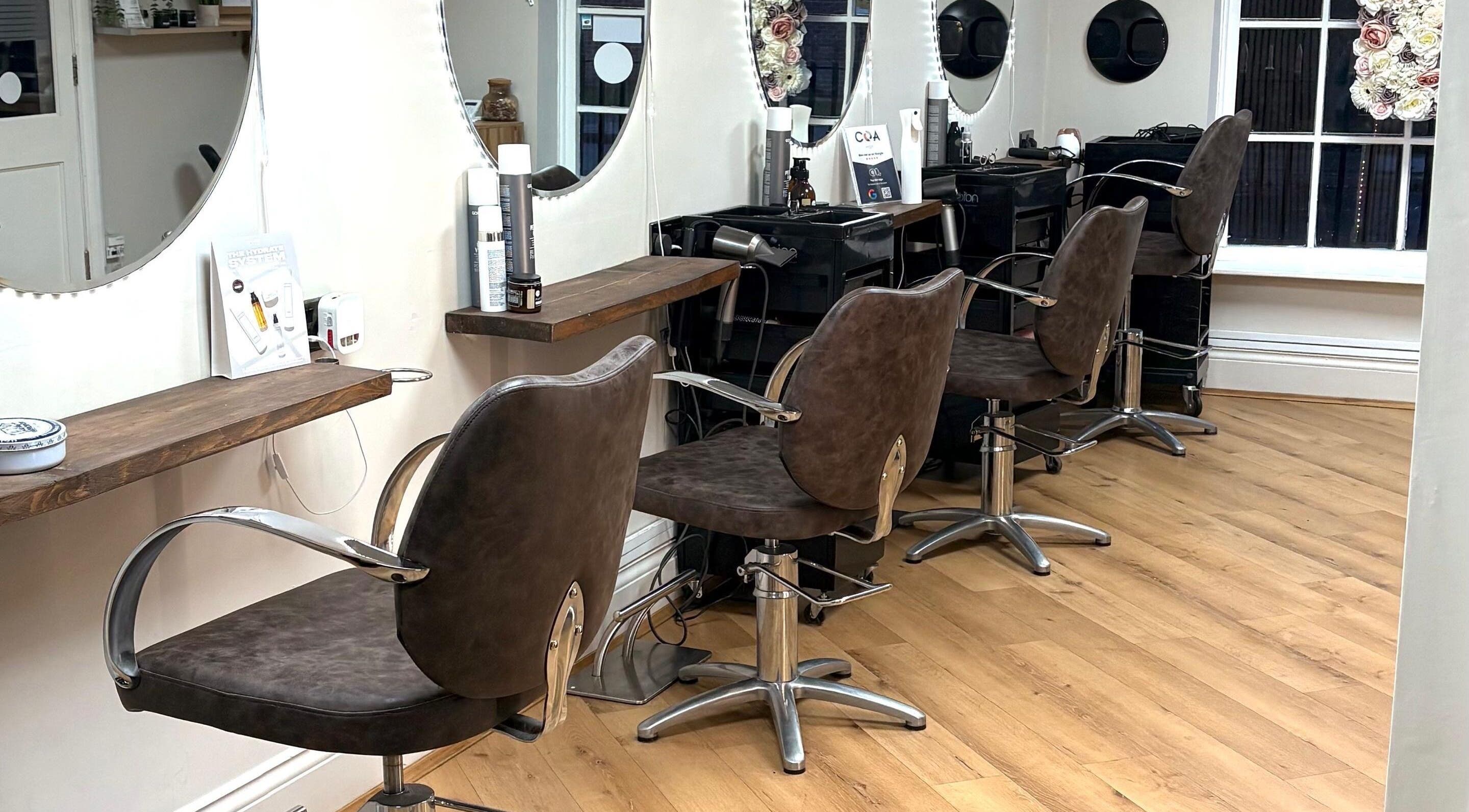 Chic salon chairs inside Coa Hair, York, England, GB, reflecting a modern beauty experience.