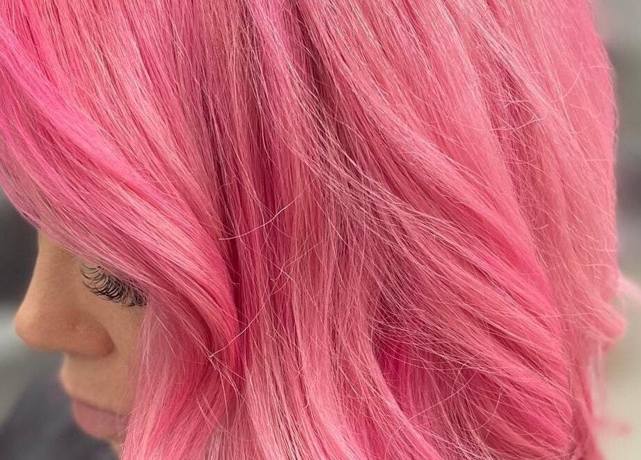 Vibrant pink hairstyle at Coa Hair, York, England, GB, showcasing soft curls and stylish flair.