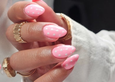 Close-up of pink polka dot nails at The Glow Way - TGW in Bedford, England, GB showcasing trendy nail art.