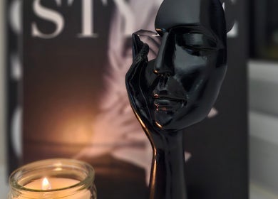 Elegant black sculpture and candle setting at The Glow Way - TGW, Bedford, England, GB.
