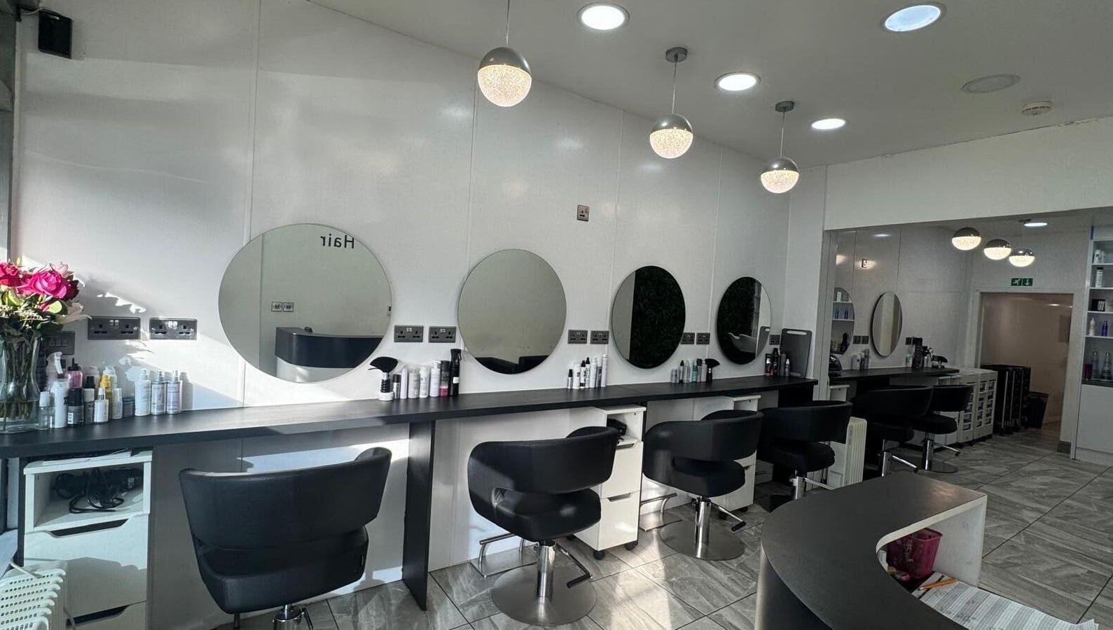 Elegant hair salon interior at Twisted Hair, Manchester, England, GB featuring sleek stations and plush chairs.