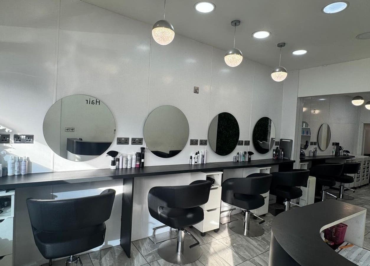 Elegant hair salon interior at Twisted Hair, Manchester, England, GB featuring sleek stations and plush chairs.