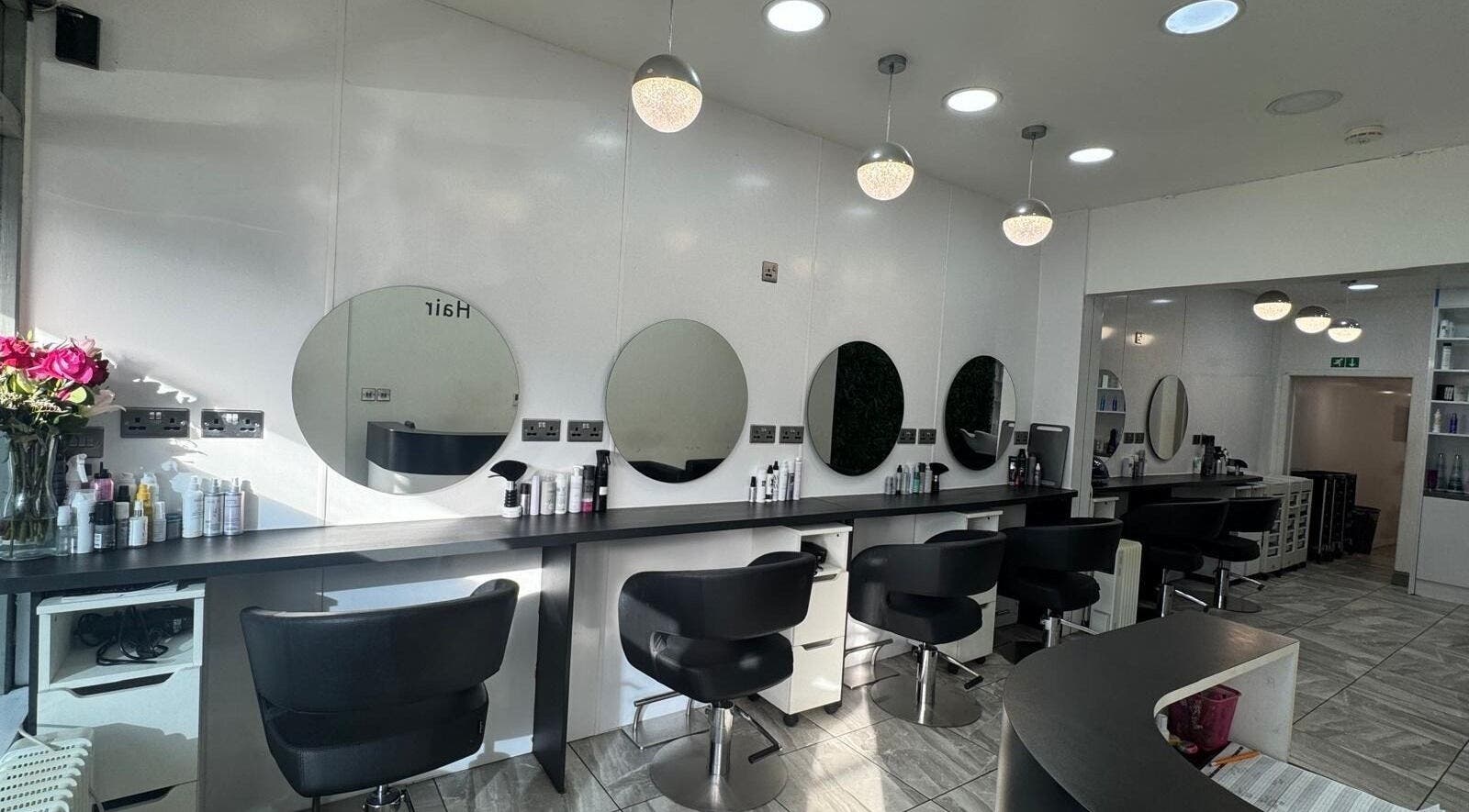 Elegant hair salon interior at Twisted Hair, Manchester, England, GB featuring sleek stations and plush chairs.