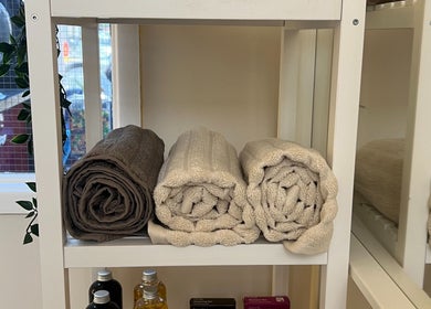 Neatly rolled towels on a shelf at Dasa Luxe in Manchester, England, GB offer a cozy spa ambiance.