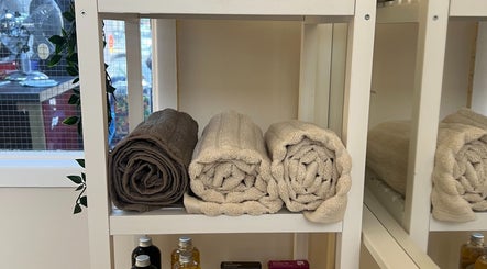 Neatly rolled towels on a shelf at Dasa Luxe in Manchester, England, GB offer a cozy spa ambiance.