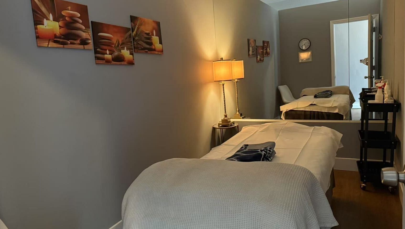 Serene massage room at Unik Spa, Nyack, New York, US, featuring a cozy bed and soothing decor.