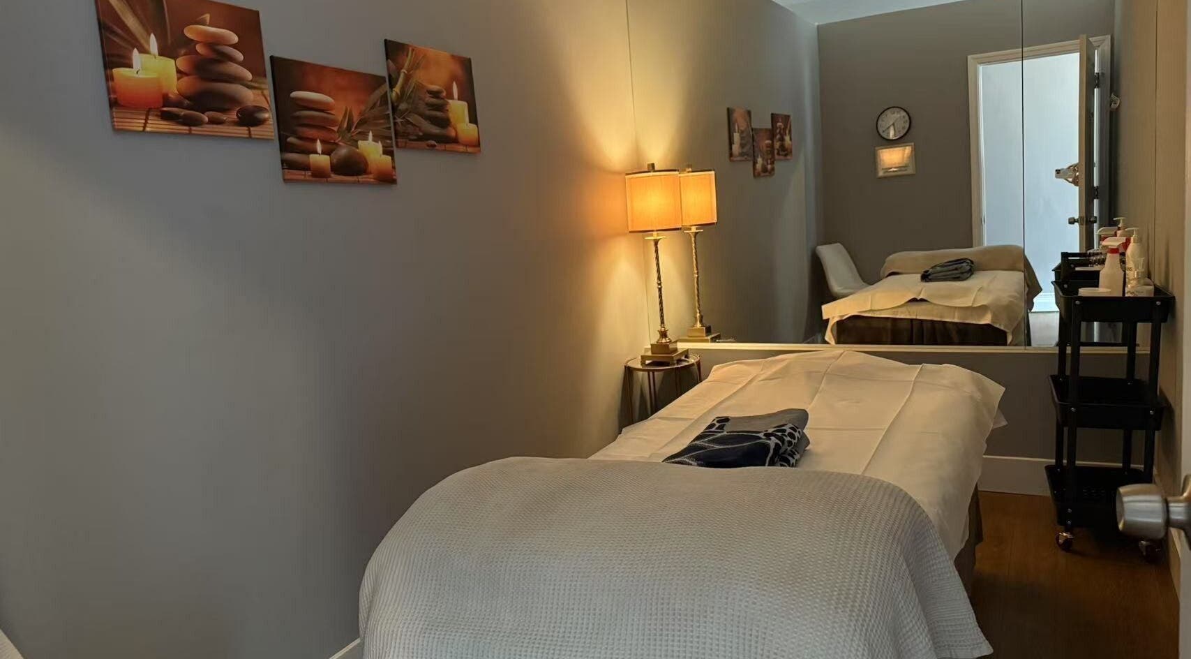 Serene massage room at Unik Spa, Nyack, New York, US, featuring a cozy bed and soothing decor.