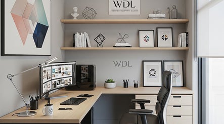 Chic office workspace at Stardaughterworks, Chennai, IN with modern desk, monitor, and artistic decor.