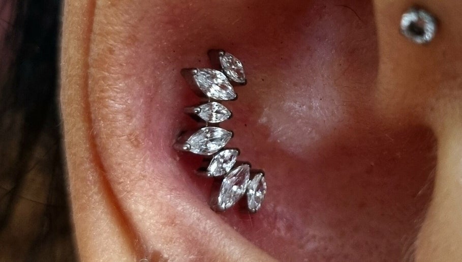 Piercing elegante all'orecchio con pietre brillanti da Sara Dacrema Piercer, Ovada, Piemonte, IT.