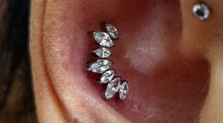 Piercing elegante all'orecchio con pietre brillanti da Sara Dacrema Piercer, Ovada, Piemonte, IT.