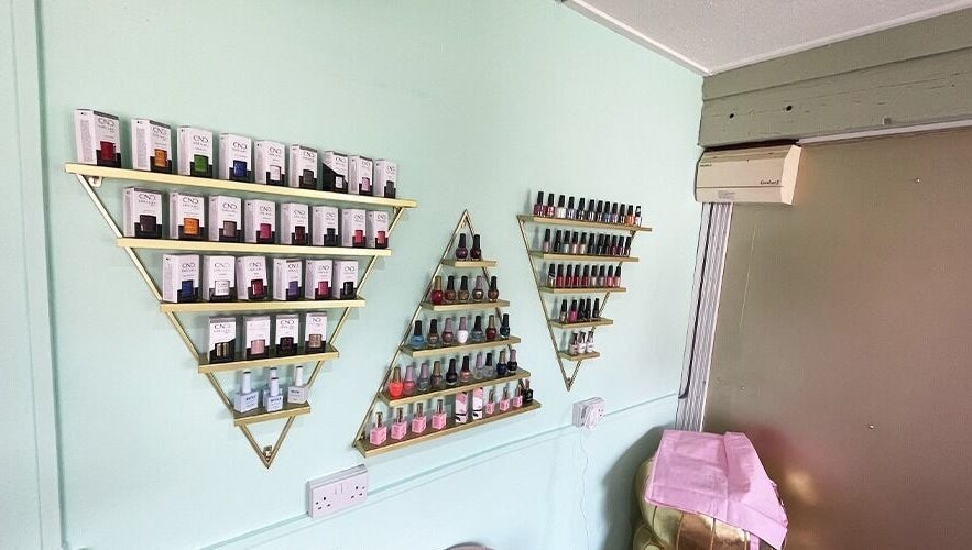 Nail polish collection on gold triangle shelves at Ritual Nail Spa, Hebden Bridge, England, GB.