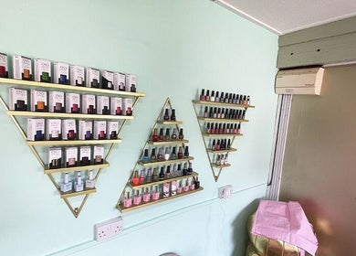 Nail polish collection on gold triangle shelves at Ritual Nail Spa, Hebden Bridge, England, GB.