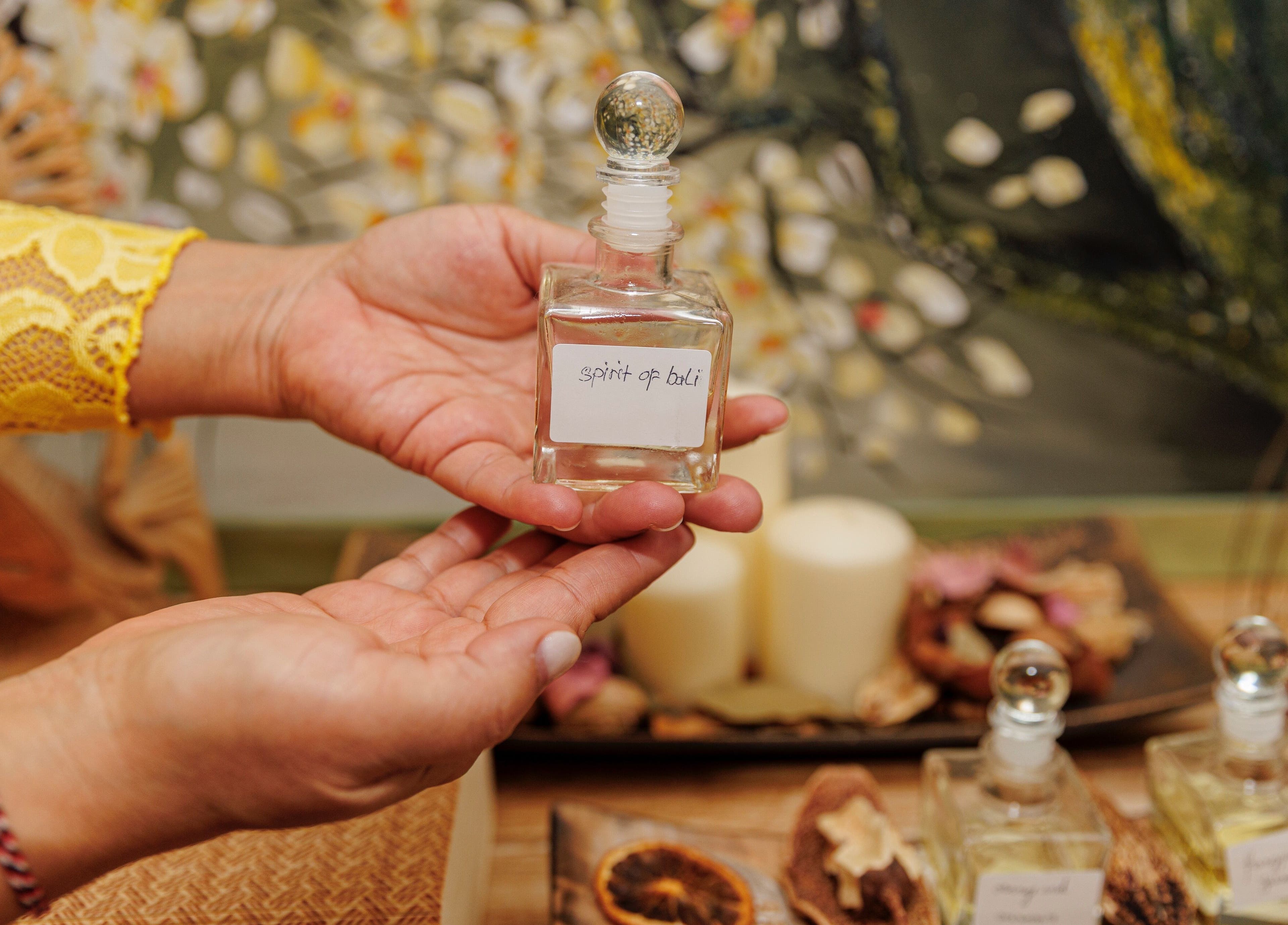 Hands showcasing a 'Spirit of Bali' aroma bottle at Taksu SPA, București, București, RO.