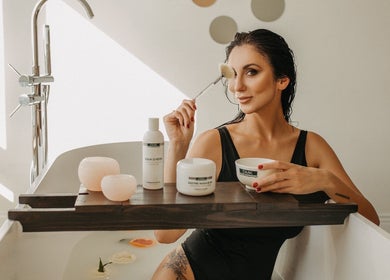 Femme se détend dans une baignoire chez InaKova, Québec, Québec, CA avec produits beauté.
