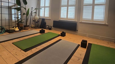 Serene yoga studio at GiYAS Therapy, London, England, GB, featuring mats, candles, and plants.