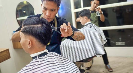 Barber crafting a sharp haircut at Manong Barbers Katipunan, QC, Quezon City, Metro Manila, PH.