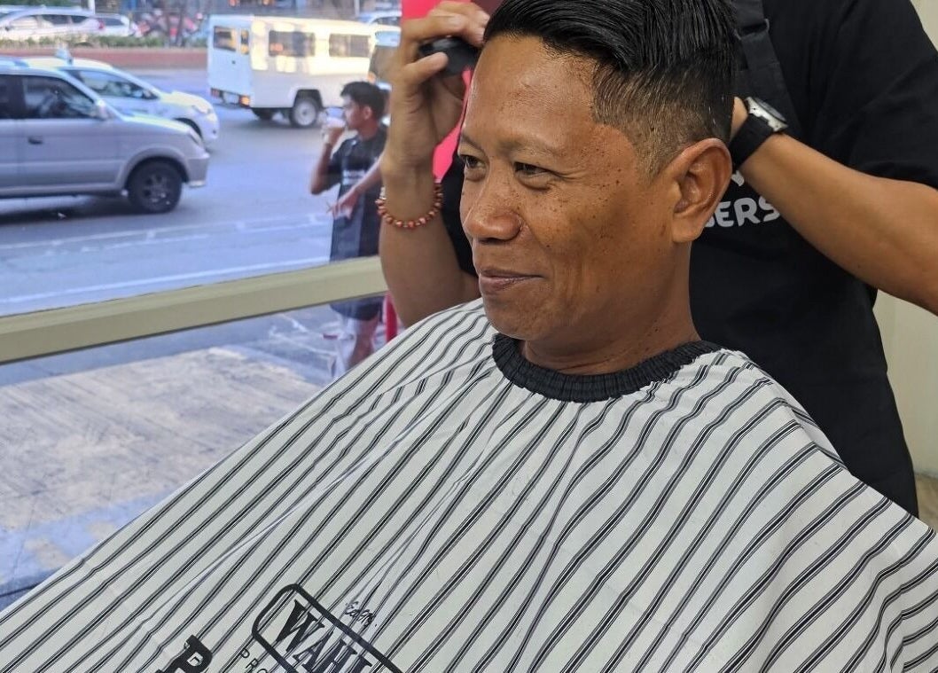 Client enjoying a haircut at Manong Barbers Katipunan, QC, Quezon City, Metro Manila, PH.