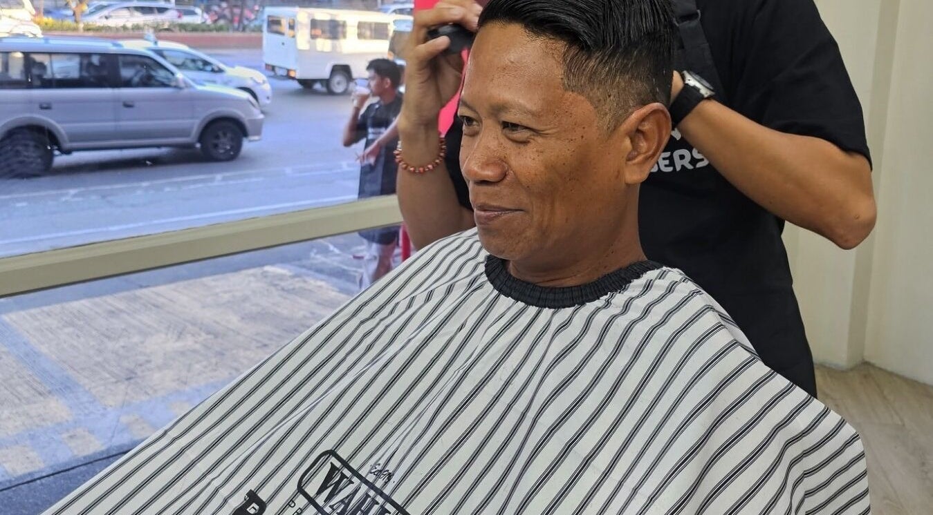 Client enjoying a haircut at Manong Barbers Katipunan, QC, Quezon City, Metro Manila, PH.