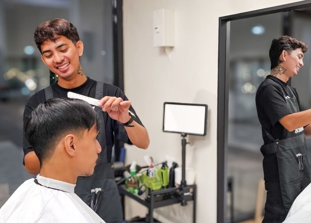 Barber styling a client's hair at Manong Barbers Studio - UP Diliman, QC, Quezon City, Metro Manila, PH.