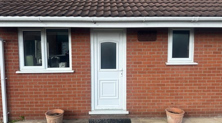 Front view of The Tanning Hut, Doncaster, England. Red brick exterior with white door and windows.